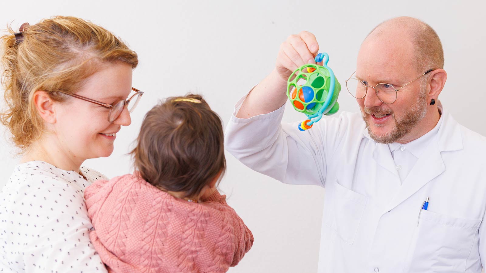 Foto von Kinderarzt mit Mutter und Kleinkind bei einer Untersuchung