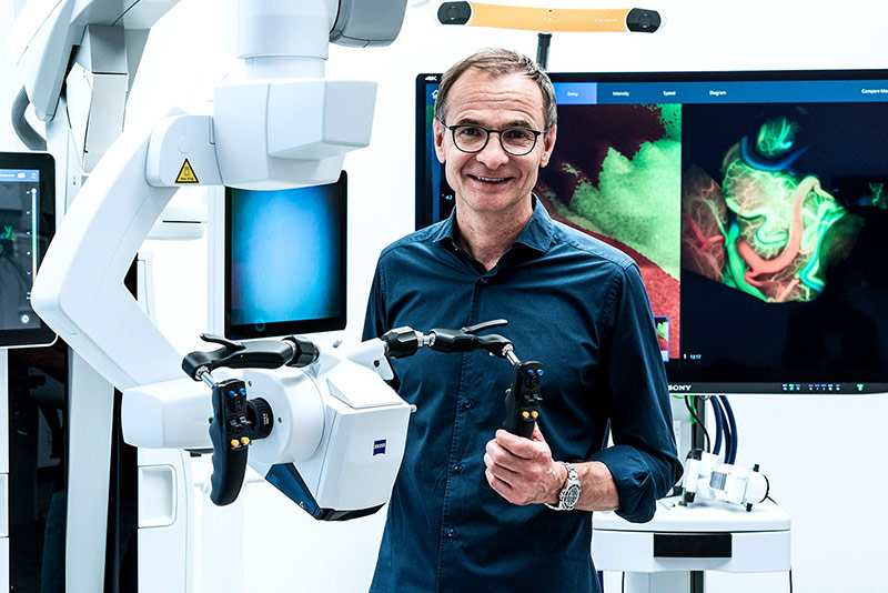 Prof. Dr. med. Andreas Raabe in front of the Zeiss-Kinevo 900 digital visualization system