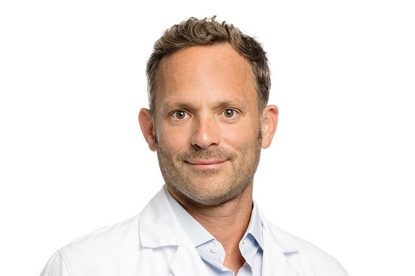 [Translate to Français:] Profilfoto von David Bervini in weissem Arztkittel auf weissem Hintergrund